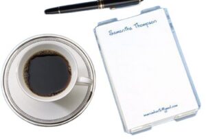 Cup of coffee with pen and notepad