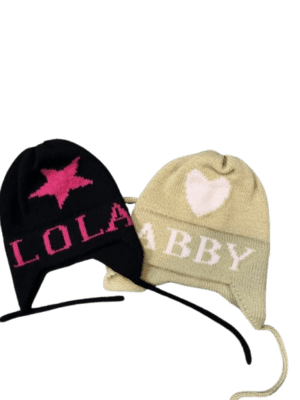 Two personalized knit hats reading LOLA and ABBY