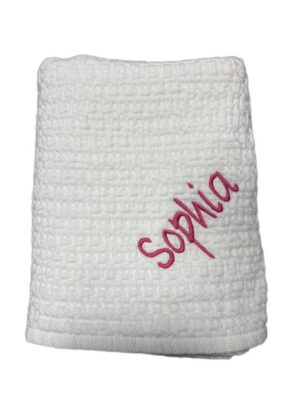 Folded white waffle towel with pink embroidery