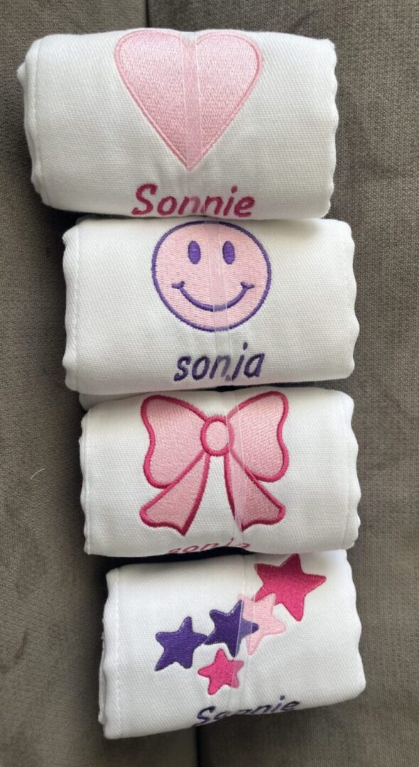 Stacked embroidered cloths with heart, smiley, bow, stars